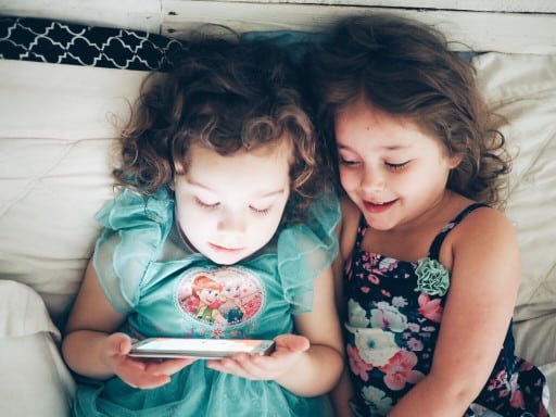 Two girls playing on a mobile phone